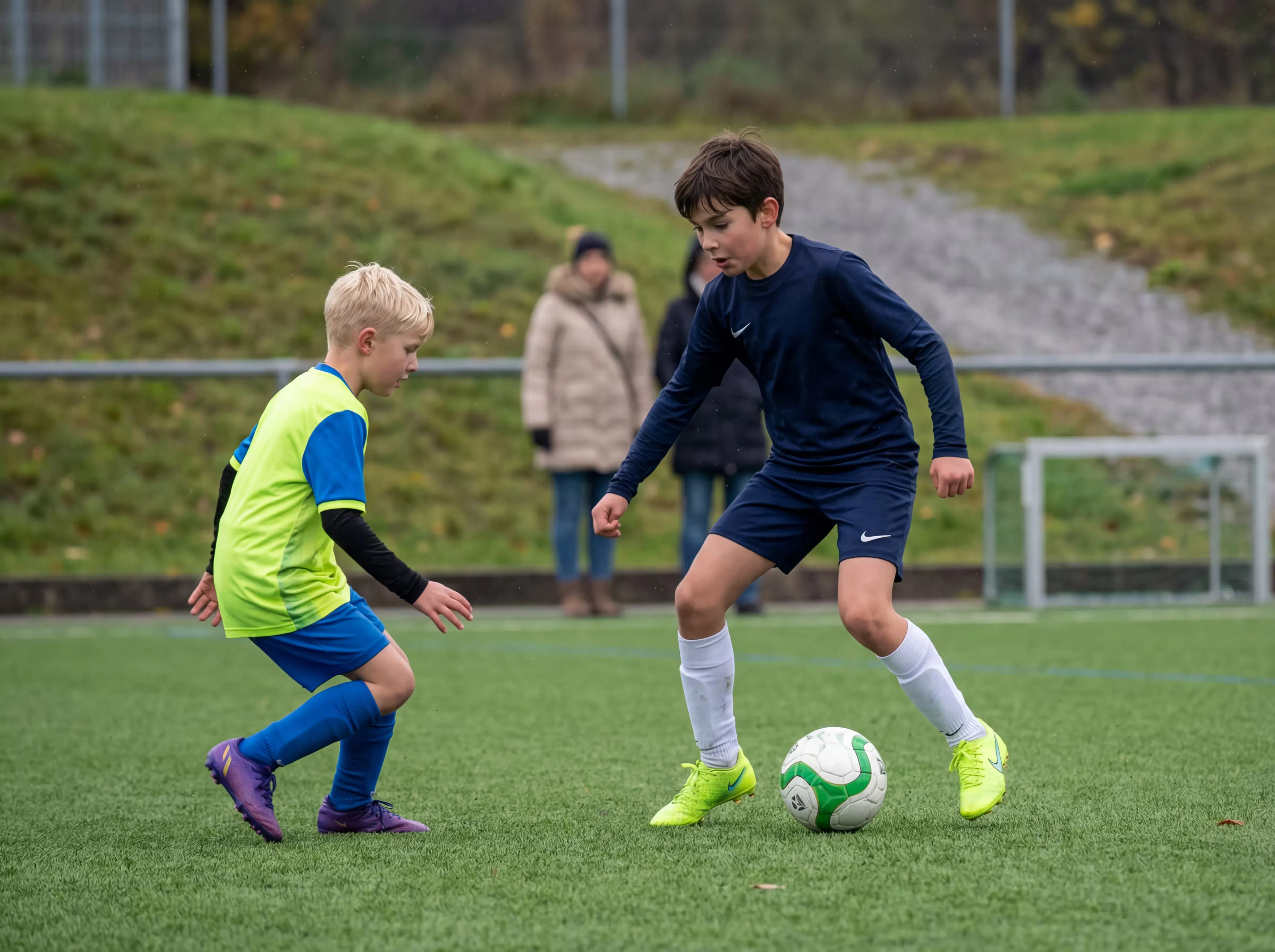 To gutter spiller fotball på en kunstgressbane